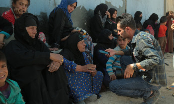 A man interviews displaced women south of Kirkuk in 2016